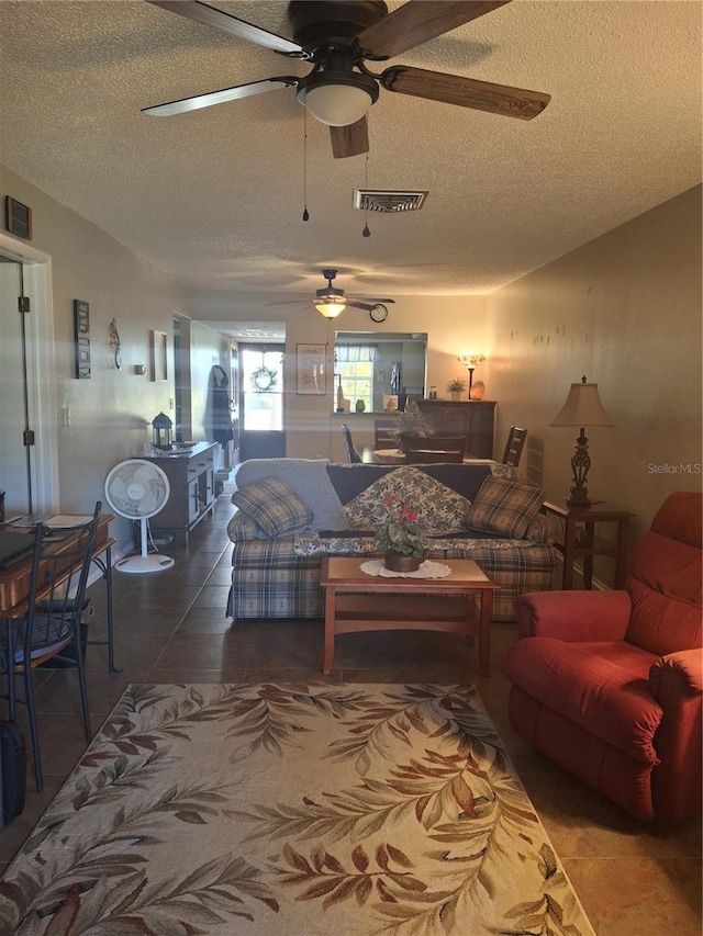 tiled living room featuring ceiling fan and a textured ceiling