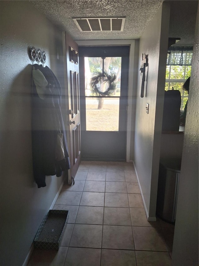 doorway to outside with tile patterned flooring