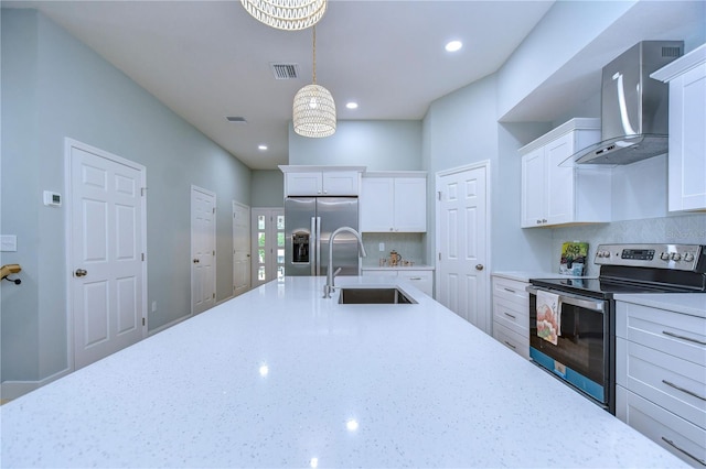 kitchen with appliances with stainless steel finishes, wall chimney range hood, a chandelier, white cabinets, and sink