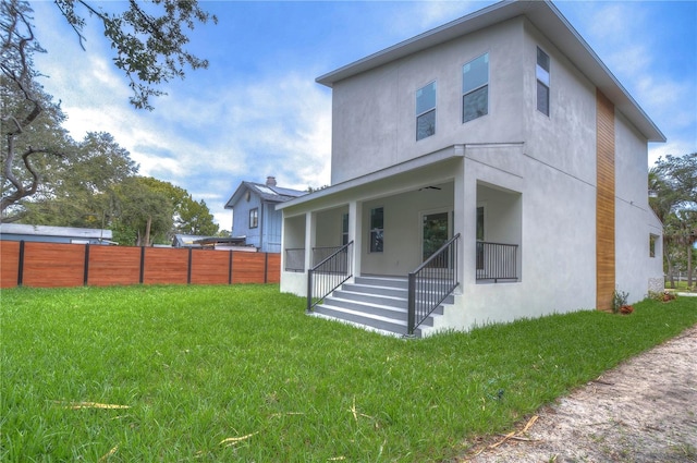 back of house with a porch and a lawn