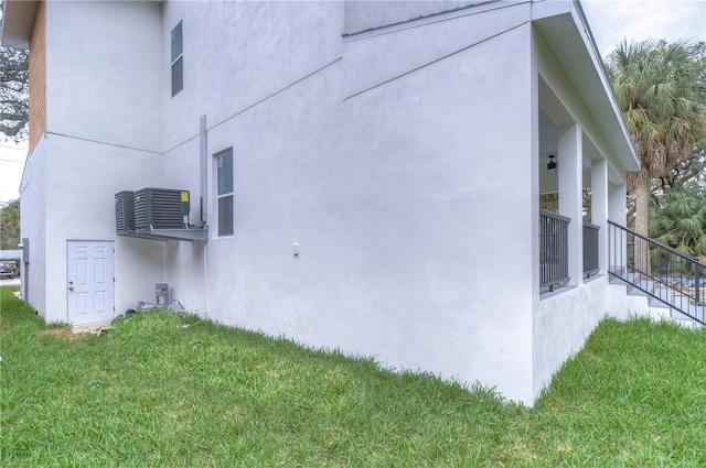 view of side of property featuring a yard and central air condition unit