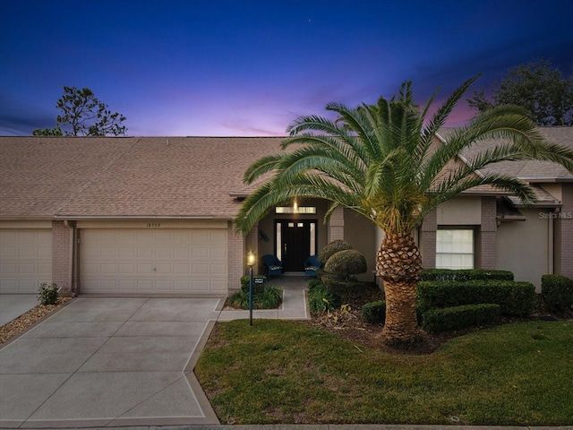 view of front facade with a garage and a lawn