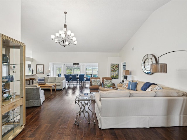 living room featuring dark wood-type flooring, a chandelier, and vaulted ceiling