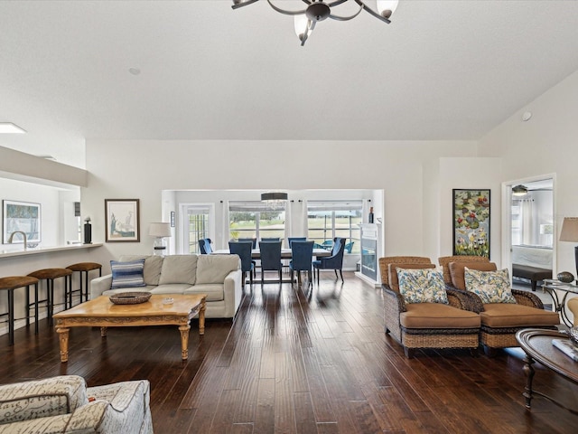 living room with sink, dark hardwood / wood-style floors, and a notable chandelier