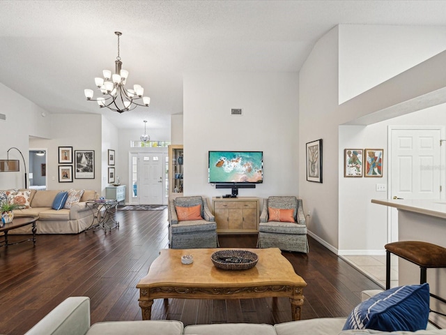 living room featuring a chandelier, dark hardwood / wood-style floors, and vaulted ceiling