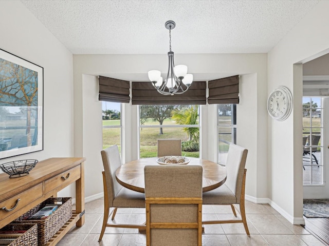 dining area with a textured ceiling, light tile patterned floors, and a notable chandelier