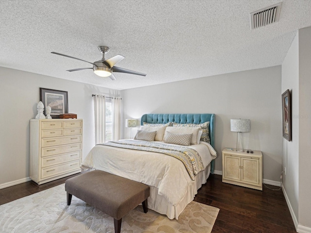 bedroom featuring a textured ceiling, ceiling fan, and dark hardwood / wood-style flooring