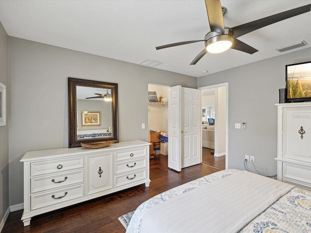 bedroom featuring a closet, ceiling fan, a spacious closet, and dark wood-type flooring