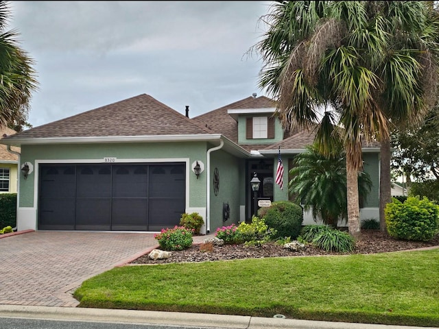 view of front of property with a garage and a front lawn