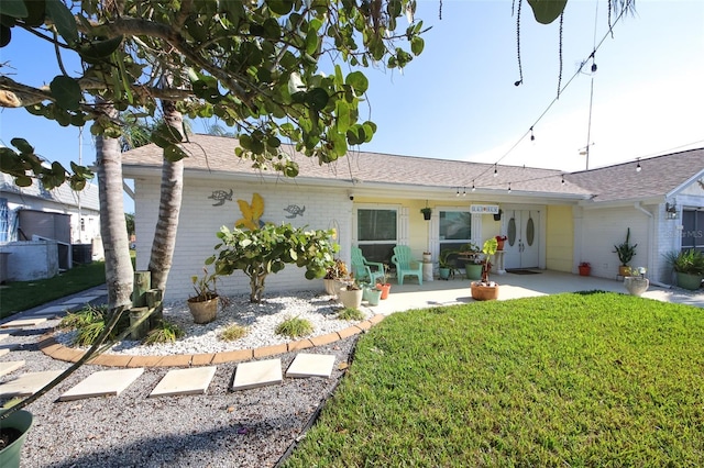 view of front of house featuring a patio and a front lawn