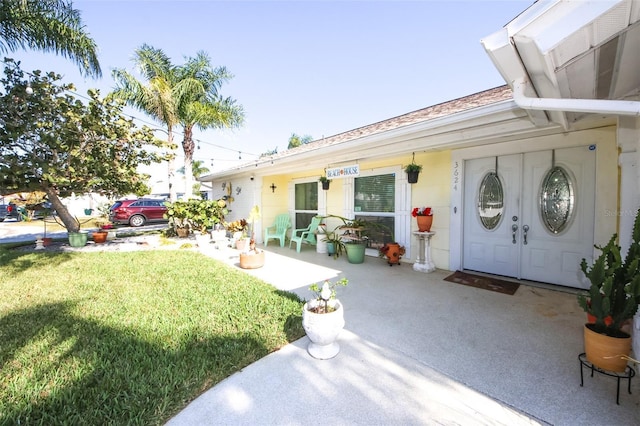 view of exterior entry with a yard