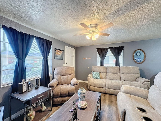 living room with ceiling fan, a textured ceiling, and hardwood / wood-style flooring