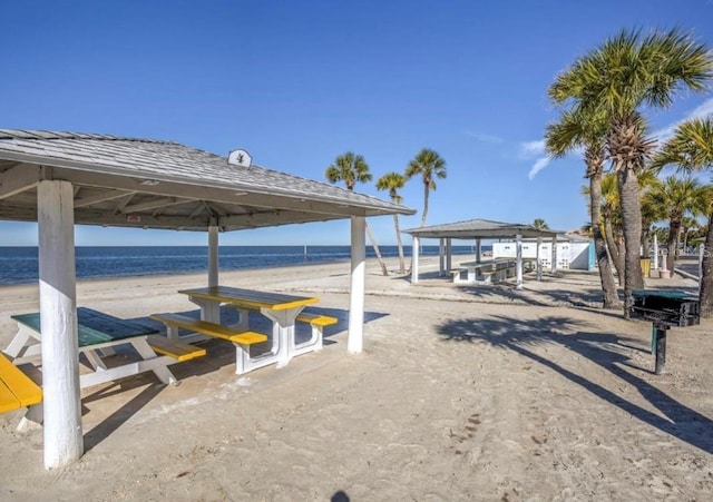 dock area with a water view, a gazebo, and a view of the beach