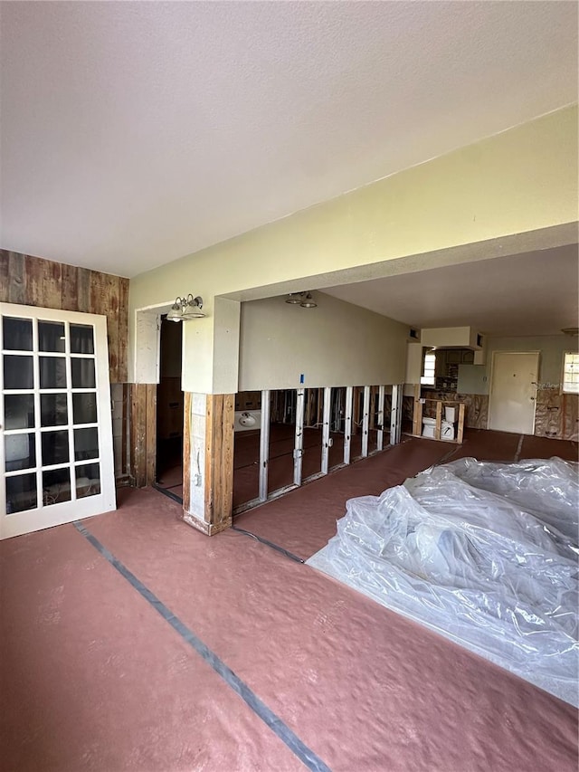 unfurnished room featuring wooden walls