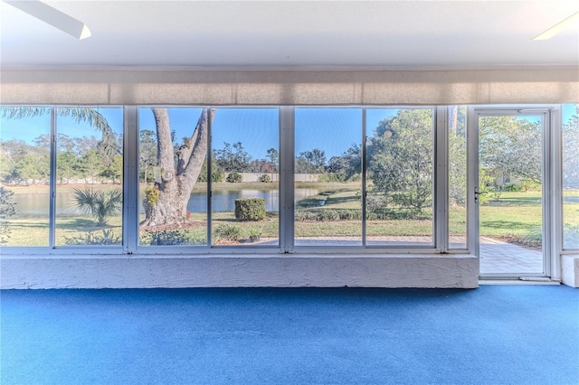 unfurnished sunroom with a wealth of natural light and a water view