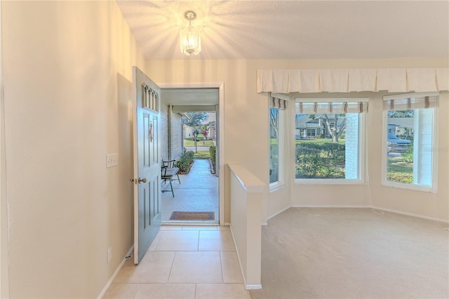 doorway featuring a textured ceiling and light tile patterned floors