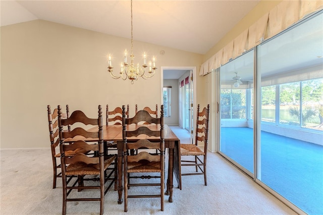 carpeted dining room featuring lofted ceiling and an inviting chandelier