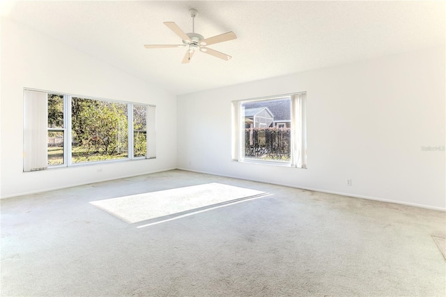 empty room with ceiling fan, carpet flooring, and lofted ceiling