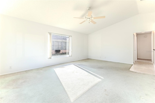 spare room with vaulted ceiling, ceiling fan, and light carpet