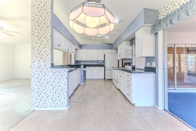 kitchen featuring light carpet, ceiling fan, white cabinetry, and white appliances