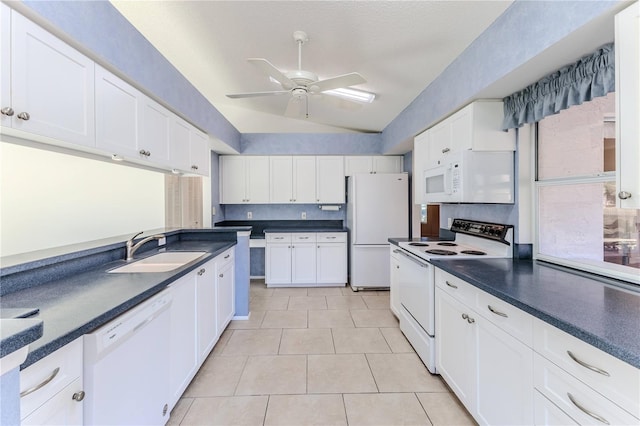 kitchen featuring light tile patterned floors, white appliances, vaulted ceiling, white cabinets, and sink