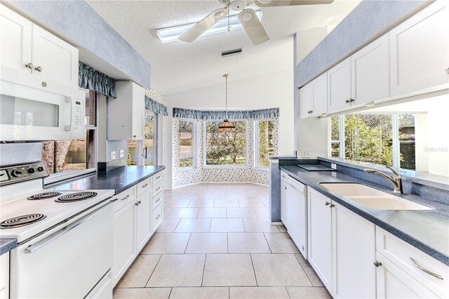 kitchen with white cabinets, vaulted ceiling, and white appliances