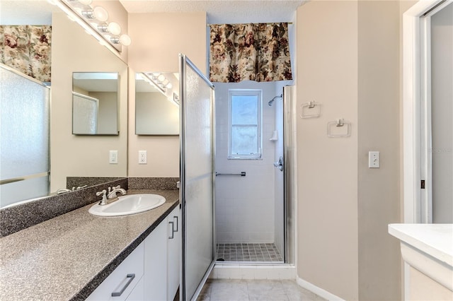 bathroom featuring a textured ceiling, an enclosed shower, vanity, and tile patterned flooring