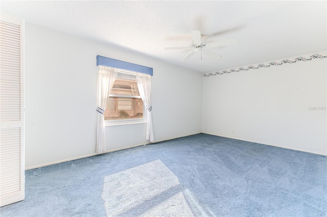 spare room with ceiling fan, a textured ceiling, and carpet flooring