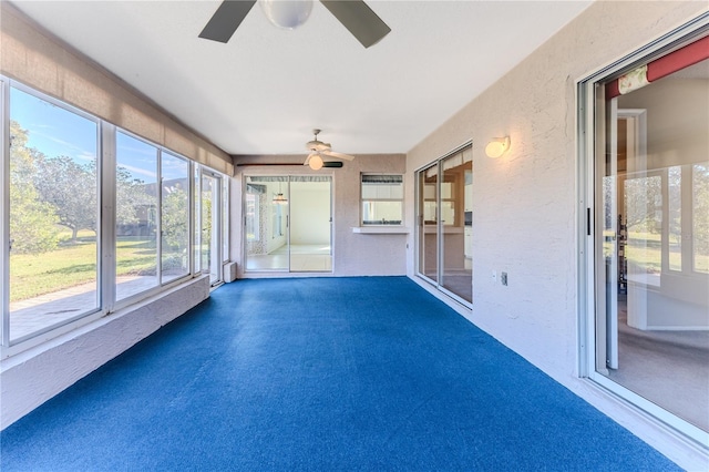 unfurnished sunroom featuring ceiling fan