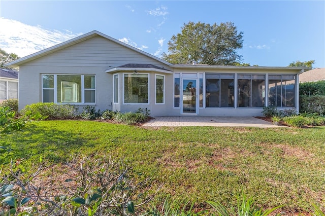 rear view of house with a patio area, a yard, and a sunroom