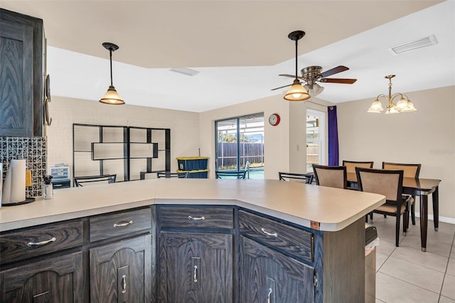 kitchen featuring pendant lighting, ceiling fan with notable chandelier, kitchen peninsula, and light tile patterned floors