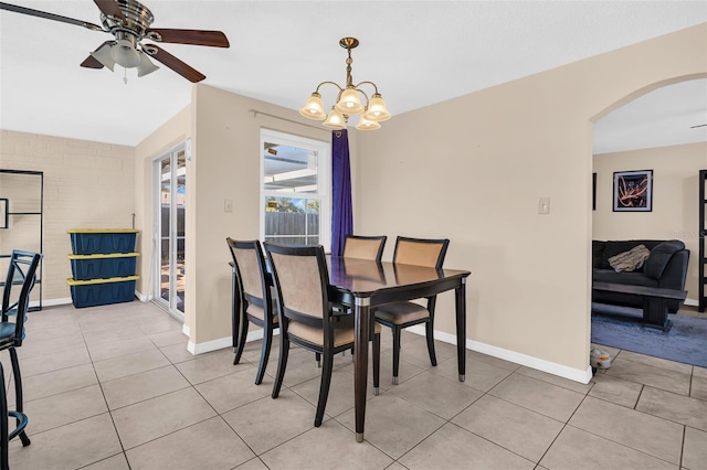 dining area featuring light tile patterned flooring and ceiling fan with notable chandelier