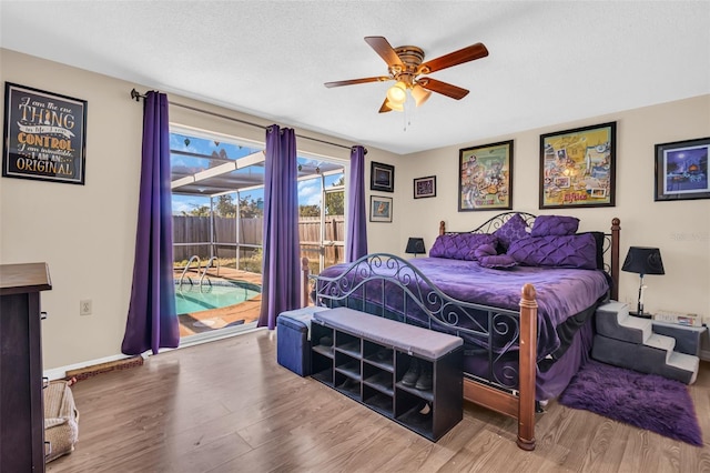 bedroom featuring hardwood / wood-style flooring, a textured ceiling, ceiling fan, and access to exterior