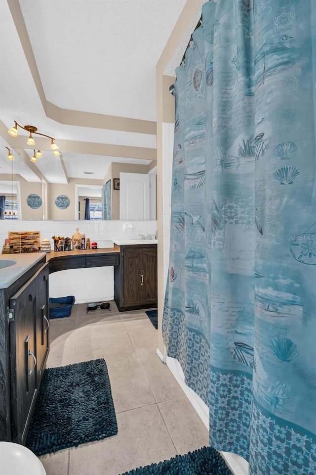 bathroom featuring tile patterned flooring, vanity, decorative backsplash, and a shower with curtain