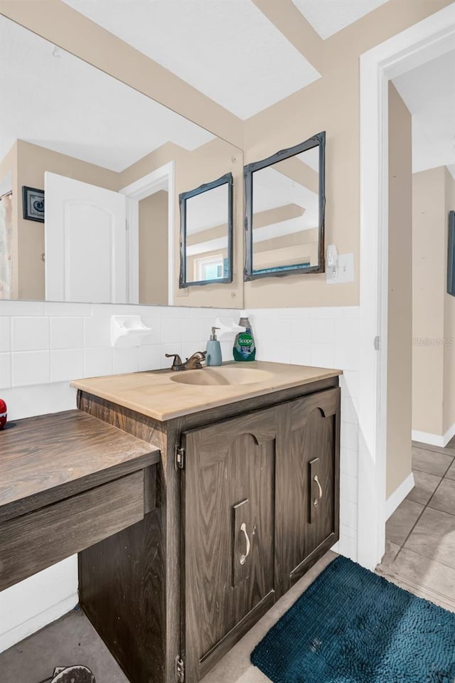 bathroom with tile patterned floors, vanity, tile walls, and decorative backsplash