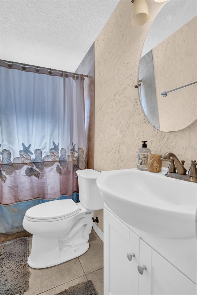 bathroom featuring toilet, a textured ceiling, walk in shower, tile patterned flooring, and vanity