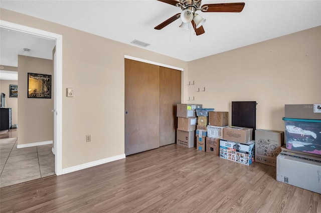 interior space with ceiling fan, a closet, and hardwood / wood-style flooring