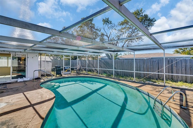 view of pool with a lanai, a patio, and grilling area