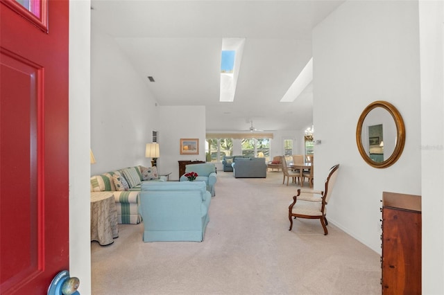 carpeted living room featuring ceiling fan and lofted ceiling with skylight