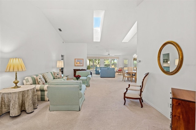 carpeted living room featuring ceiling fan, a skylight, and high vaulted ceiling