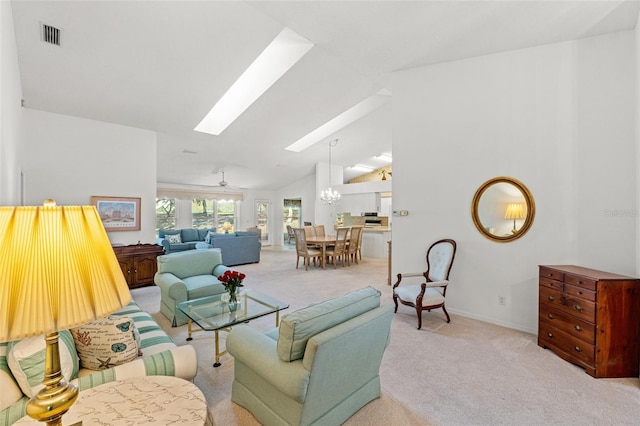 carpeted living room featuring ceiling fan with notable chandelier and lofted ceiling with skylight