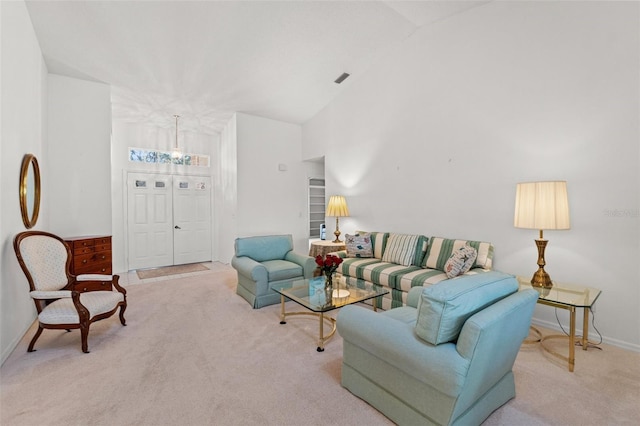 living room with an inviting chandelier, carpet flooring, and high vaulted ceiling