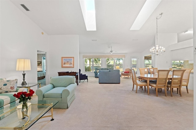 living room featuring ceiling fan with notable chandelier, lofted ceiling with skylight, and light carpet