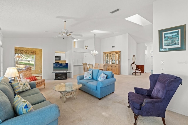 carpeted living room with high vaulted ceiling and ceiling fan with notable chandelier