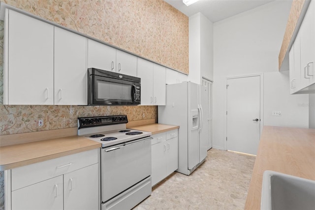 kitchen with white cabinetry, sink, white appliances, and tasteful backsplash