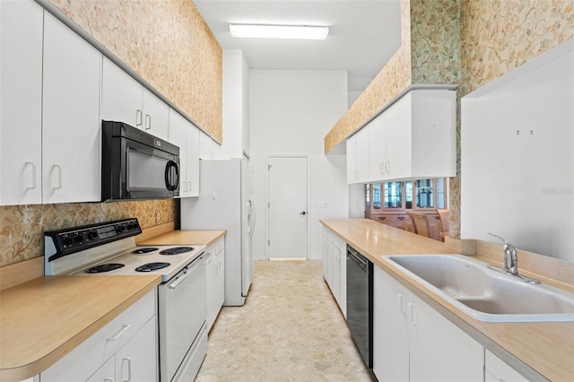 kitchen featuring sink, white cabinetry, black appliances, and tasteful backsplash