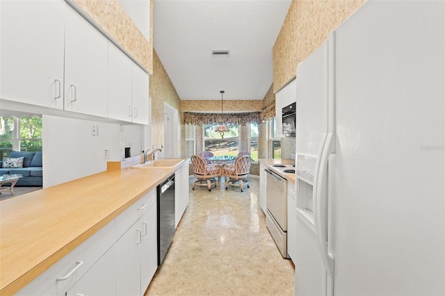 kitchen with white fridge with ice dispenser, white cabinets, decorative light fixtures, sink, and range with electric stovetop