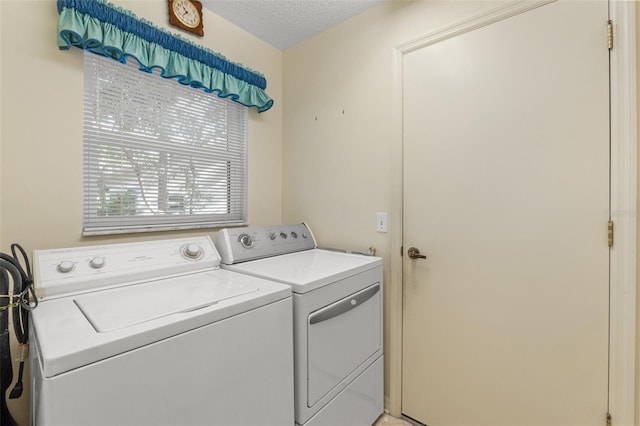 washroom featuring a textured ceiling and washing machine and clothes dryer