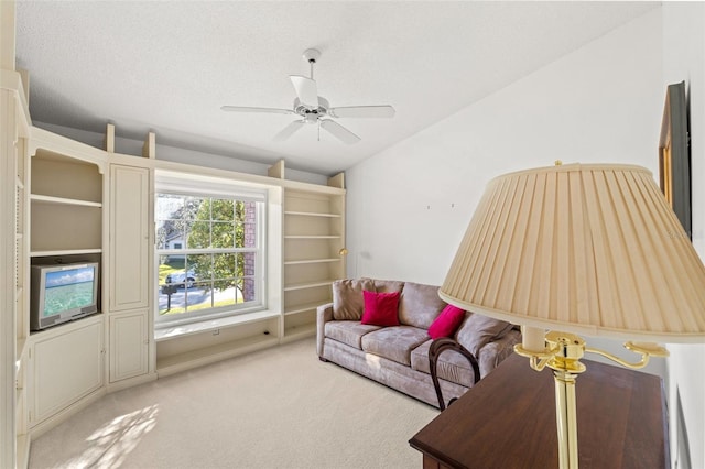 carpeted living room with ceiling fan, a textured ceiling, and lofted ceiling