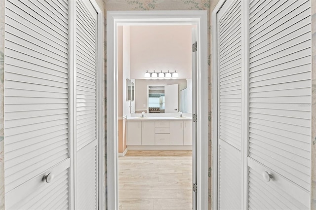 hall with light hardwood / wood-style floors and sink